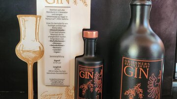 An elegant set of gin bottles and a stylish display. The packaging highlights the quality and design of the product.