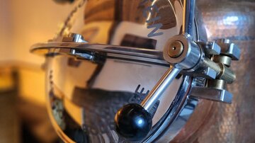 A shiny metal gauge with a round display. The details are meticulously crafted and reflect the surroundings.