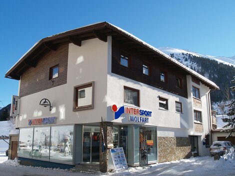 A sporty shop in a snow-covered area. The facade features large windows and clear signage.