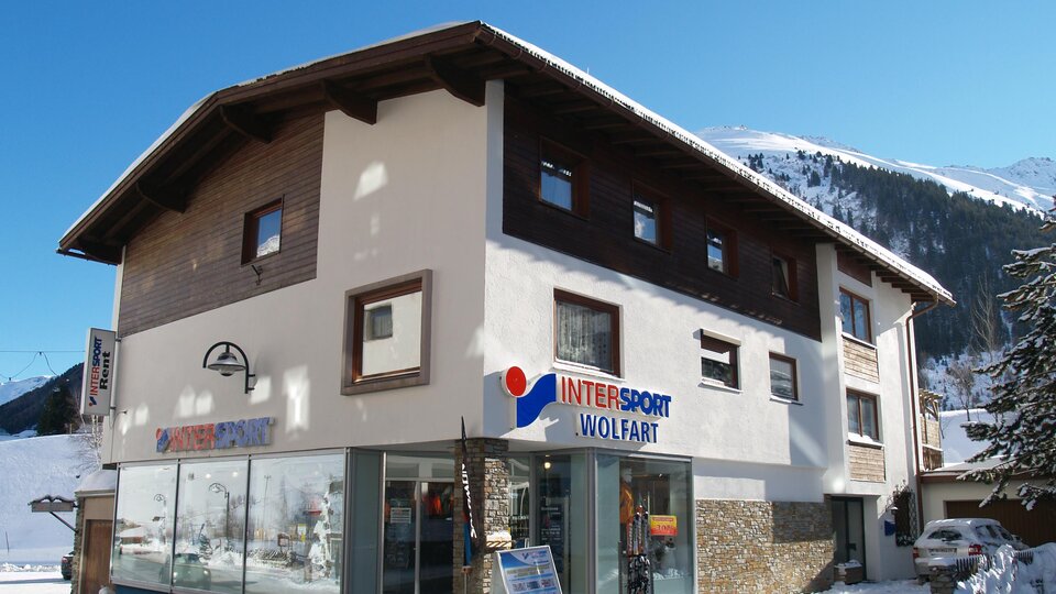 A sporty shop in a snow-covered area. The facade features large windows and clear signage.